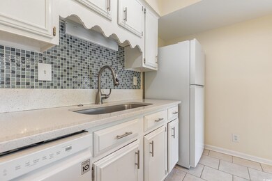 Kitchen with white cabinets, sink, white dishwashe
