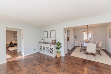 Dining area with dark wood-type flooring and a notable chandelier