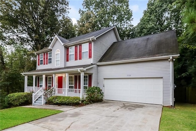 Colonial home featuring a garage, a front yard, an