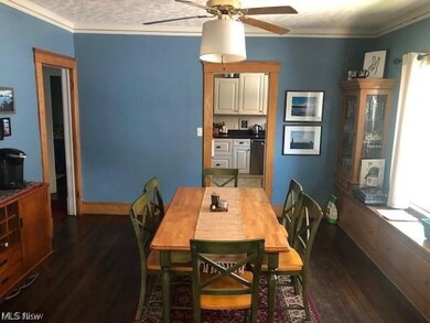 Dining space with ceiling fan, dark hardwood / wood-style flooring, and ornamental molding