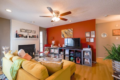 Living area with a brick fireplace, ceiling fan, r