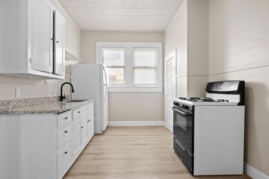Kitchen featuring white cabinetry, light wood-typ