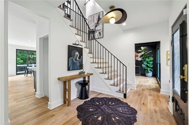 Entrance foyer with wood finished floors, stairs, and baseboards