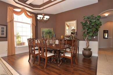 Formal dining room with tray ceiling, wood floors 