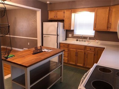 The kitchen features maple cabinets with a movable