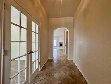 Corridor with arched walkways, french doors, a te