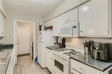 Kitchen featuring white appliances, washer and cl