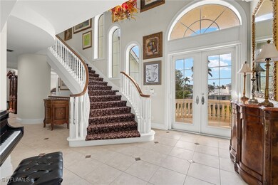 Foyer with a towering ceiling, light tile patterne