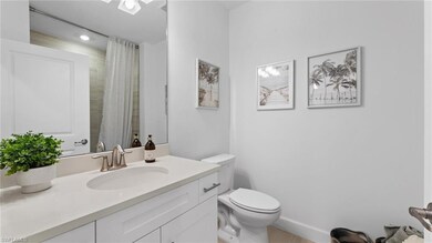 Full bath featuring baseboards, vanity, toilet, an