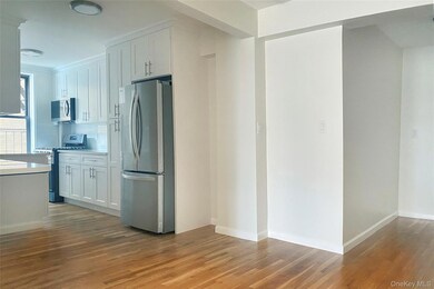 Kitchen featuring appliances with stainless steel finishes, white cabinetry, light wood-style flooring, and tasteful backsplash