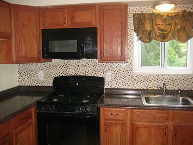 Kitchen. The kitchen is accented by a tiled back s