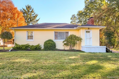 View of front of property featuring a chimney and a front lawn