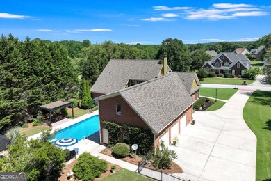 View of level drive with 3 car garage & pool/ hot tub & entertaining area