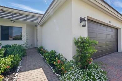 View of side of home with decorative driveway, two
