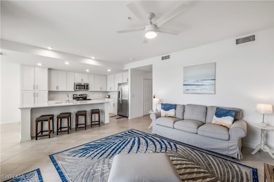 Tiled living room featuring ceiling fan and sink