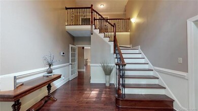 Welcoming foyer entry hall. All new balusters, rich hardwood flooring with walnut finish.