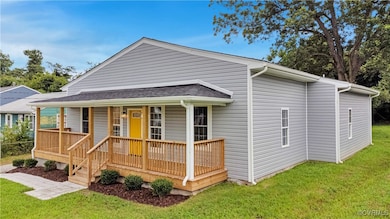 View of front of house with a porch, a front yard, and a shingled roof