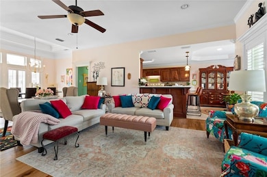 Living area featuring crown molding, light wood-ty