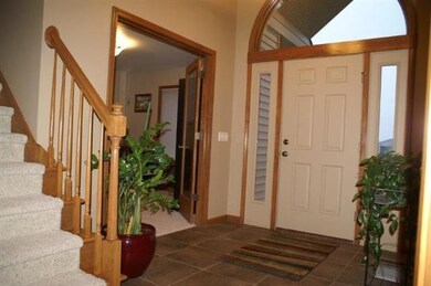 This foyer has ceramice tile floors, arched window
