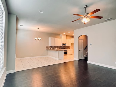 Unfurnished living room with arched walkways, recessed lighting, light wood-type flooring, a chandelier, and a ceiling fan