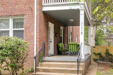 Doorway to property featuring brick siding and cov
