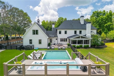 Backyard paradise includes a gorgeous pool and custom swim spa surrounded by lush greenery and privacy