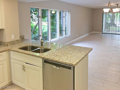 Kitchen with light stone counters, sink, dishwashe