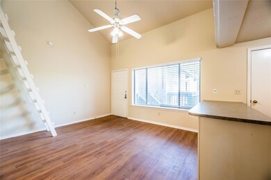 Unfurnished living room featuring light wood-style flooring, high vaulted ceiling, and ceiling fan