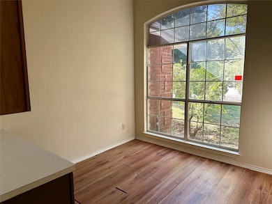 Unfurnished dining area with light wood finished floors and a textured wall