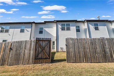 Rear view of house featuring a yard, fence, and a 
