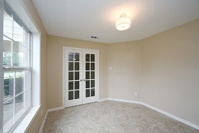 Empty room with french doors and baseboards