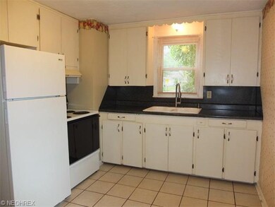 Applianced kitchen with tile floor.