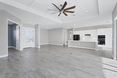 Unfurnished living room with a ceiling fan, a tray