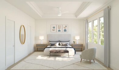 Primary suite with tray ceiling and decorative feature wall