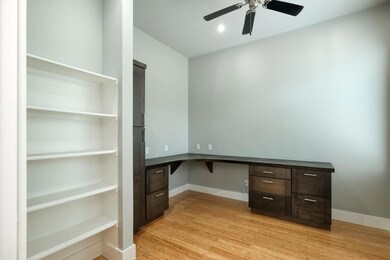 Unfurnished office featuring built in desk, light