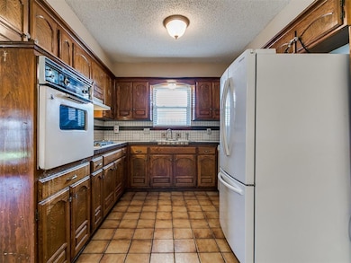 Kitchen with tasteful backsplash, dark countertops