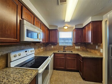 Step into your culinary sanctuary, where thoughtful design and modern amenities create an inviting space for cooking and entertaining. The kitchen showcases a sleek granite countertop that provides a durable and attractive workspace for meal preparation.