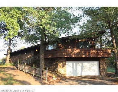 Facade/Exterior Front. Small double car garage with an above wrap around porch , with sliding glass doors