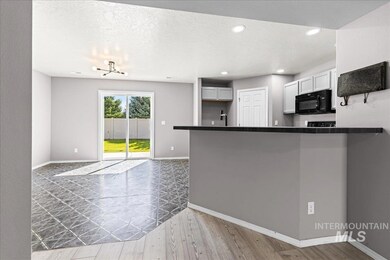 Kitchen featuring black microwave, dark countertops, wood finished floors, a peninsula, and recessed lighting
