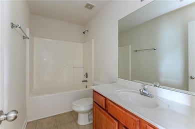 Full bathroom featuring toilet,  shower combination, vanity, and tile patterned floors