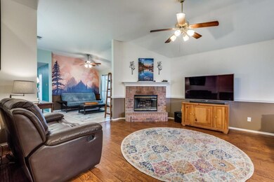 Living room with a brick fireplace, lofted ceiling