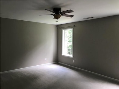 Carpeted spare room featuring baseboards and ceiling fan
