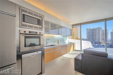 Kitchen featuring built in appliances, a sink, lig