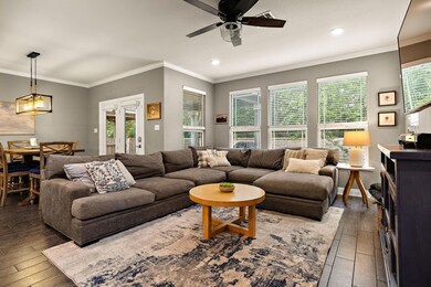 Living room with ceiling fan, ornamental molding,
