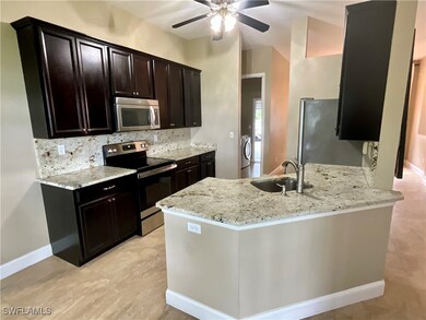 Kitchen with stainless steel appliances, tasteful backsplash, light stone countertops, and a peninsula