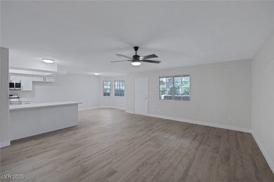 Unfurnished living room with a ceiling fan, basebo