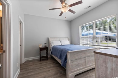 Bedroom featuring ceiling fan, dark wood-style flo
