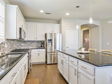 Kitchen with sink, a kitchen island, white cabinet