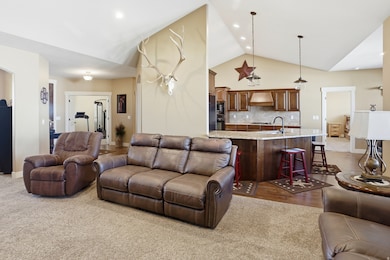 Living room with high vaulted ceiling, recessed lighting, and dark wood-type flooring