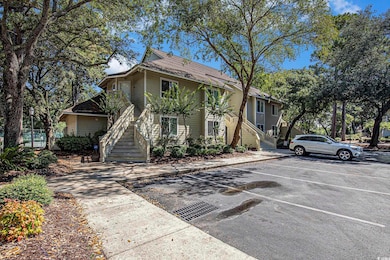 View of front of home with stairs and uncovered parking